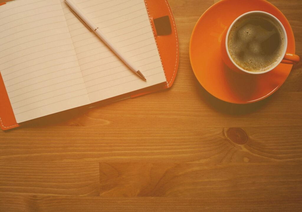 coffee cup and notebook on desk